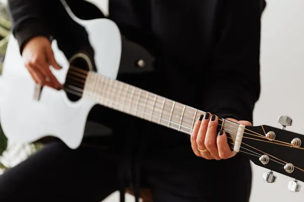 Persona tocando una guitarra acústica